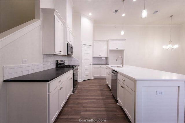 kitchen with dark hardwood / wood-style flooring, tasteful backsplash, stainless steel appliances, pendant lighting, and white cabinetry