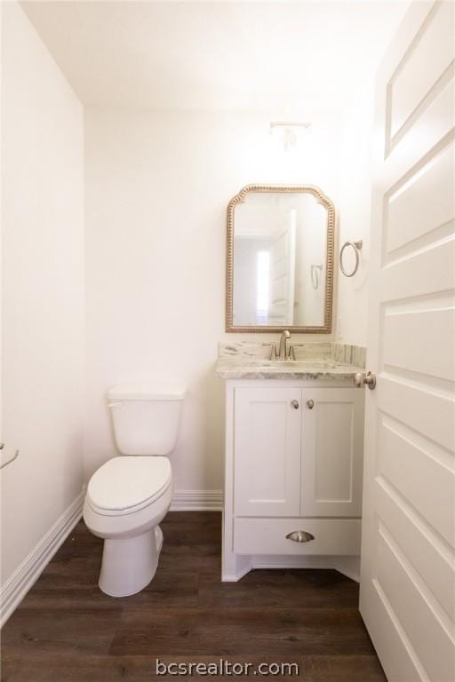 bathroom with vanity, hardwood / wood-style flooring, and toilet