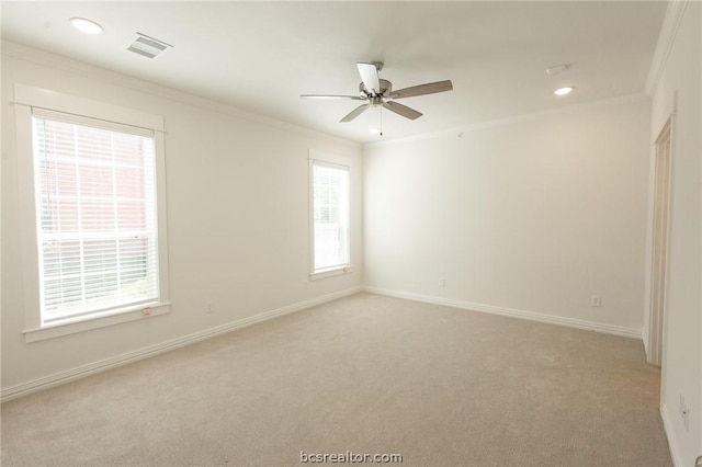 spare room with crown molding, ceiling fan, and light colored carpet