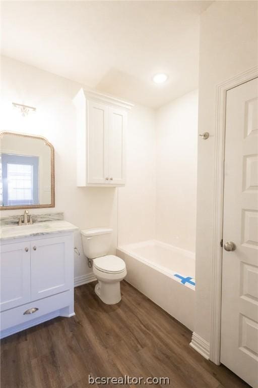 full bathroom with bathing tub / shower combination, toilet, vanity, and hardwood / wood-style flooring