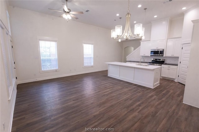 kitchen featuring pendant lighting, dark hardwood / wood-style floors, a center island with sink, and appliances with stainless steel finishes