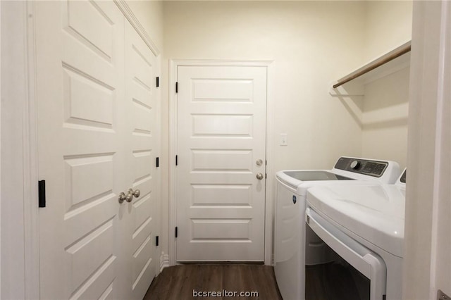 laundry room with dark wood-type flooring and washer and dryer