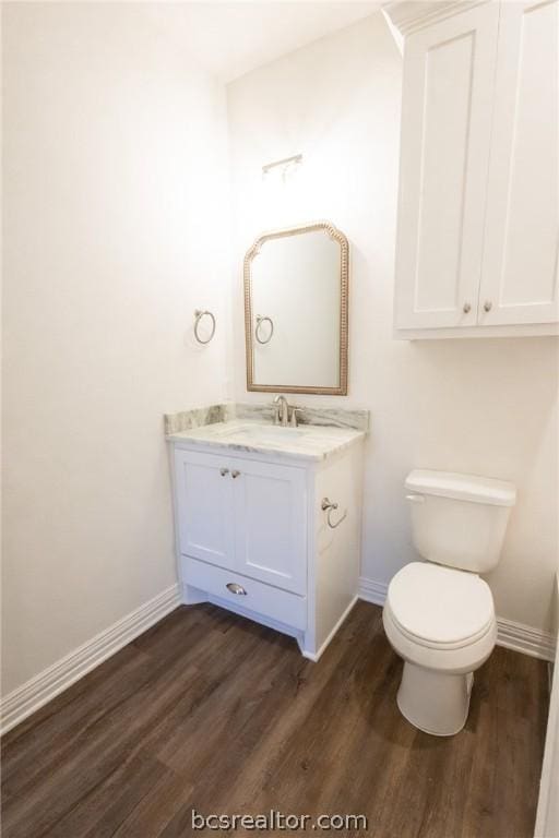 bathroom with hardwood / wood-style floors, vanity, and toilet