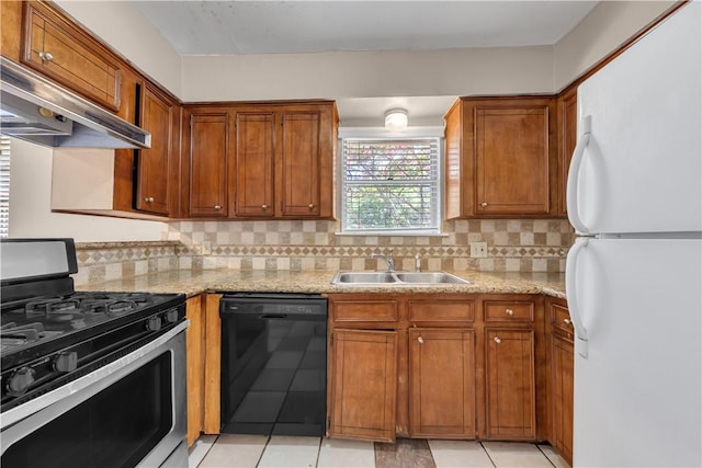 1214 Neal Pickett Dr, College Station, TX 77840 - kitchen featuring dishwasher, stainless steel gas stove, freestanding refrigerator, under cabinet range hood, and brown cabinets