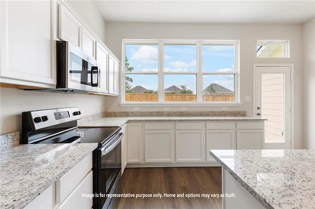 kitchen featuring light stone countertops, white cabinetry, dark wood-type flooring, and appliances with stainless steel finishes