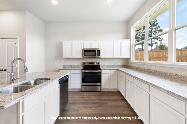 kitchen featuring light stone countertops, appliances with stainless steel finishes, sink, white cabinets, and dark hardwood / wood-style floors