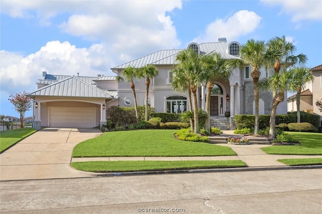 mediterranean / spanish-style home featuring a front yard and a garage