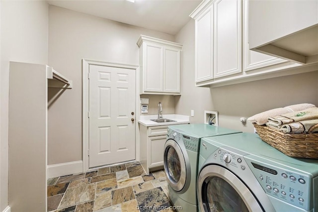 washroom with sink, cabinets, and independent washer and dryer