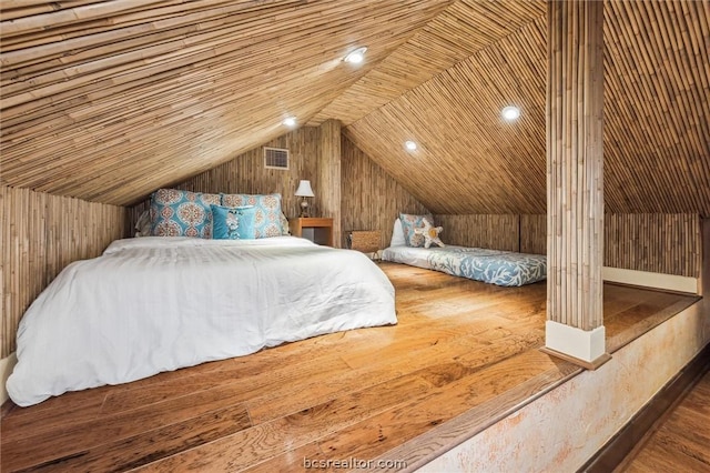 bedroom with wood-type flooring and wood walls