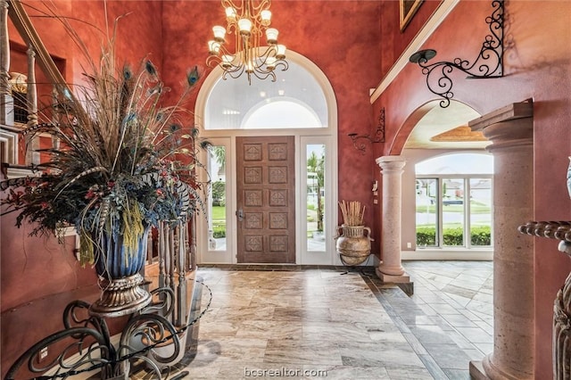 entrance foyer featuring ornate columns, plenty of natural light, and a towering ceiling