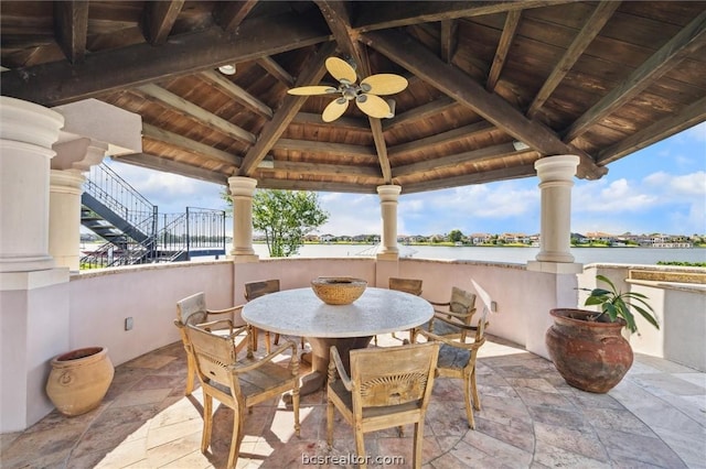 view of patio featuring a gazebo, ceiling fan, and a water view