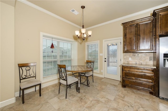 dining room with crown molding and a chandelier