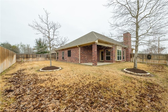 back of house featuring a patio area and a lawn