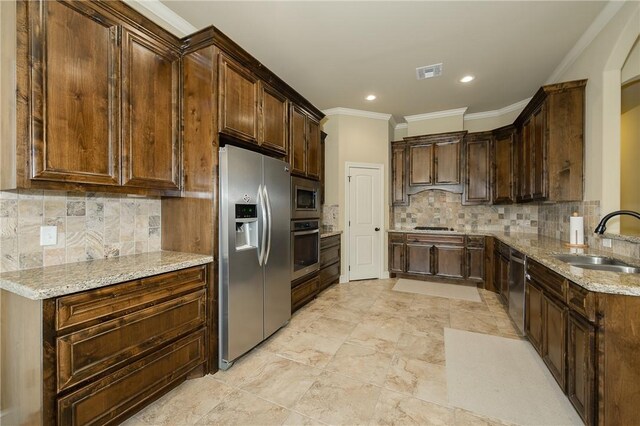 kitchen featuring light stone countertops, appliances with stainless steel finishes, sink, and crown molding