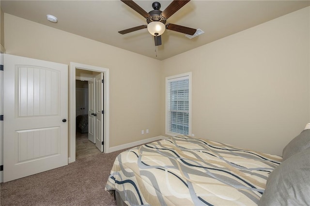 carpeted bedroom with a walk in closet, a closet, and ceiling fan