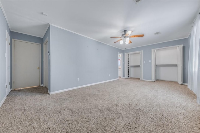 unfurnished bedroom with carpet flooring, ceiling fan, crown molding, and multiple closets