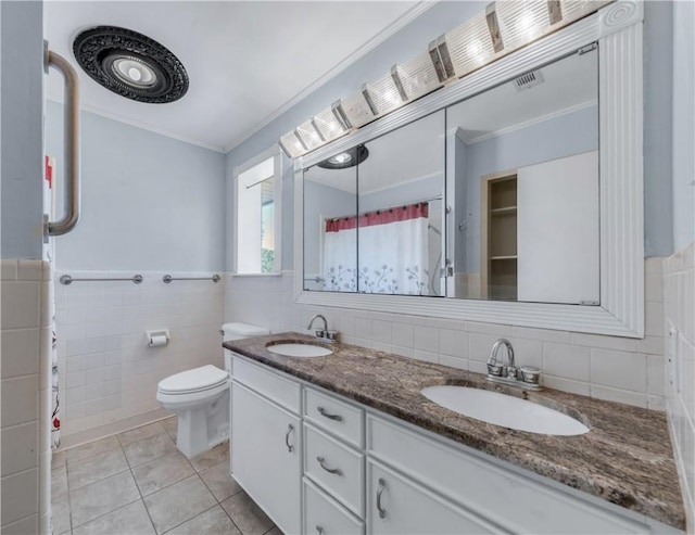 bathroom with tile patterned flooring, vanity, crown molding, and tile walls