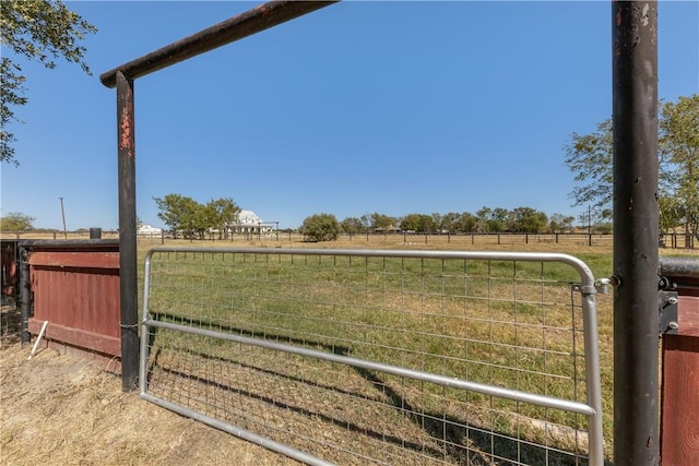 view of gate with a rural view