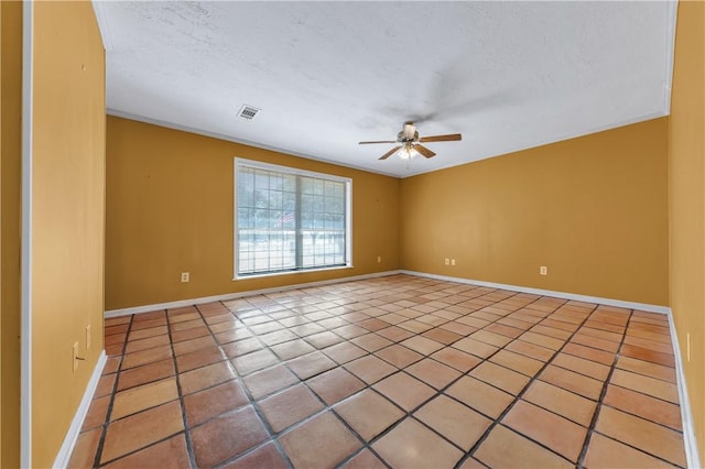 tiled empty room featuring ceiling fan and a textured ceiling