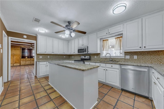 kitchen with a center island, white cabinets, stainless steel appliances, and sink