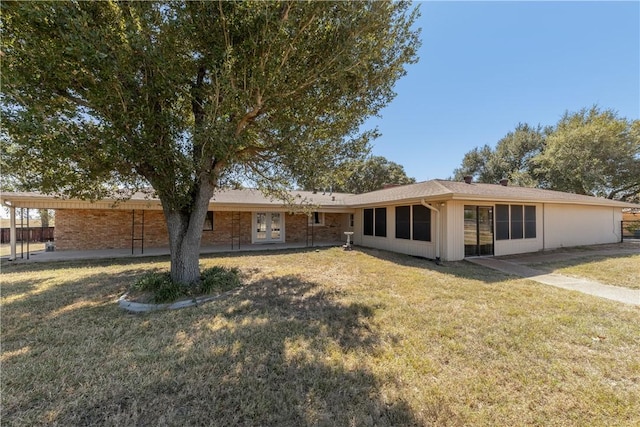 rear view of house featuring a yard