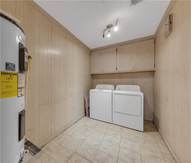 washroom with cabinets, electric water heater, separate washer and dryer, and wood walls