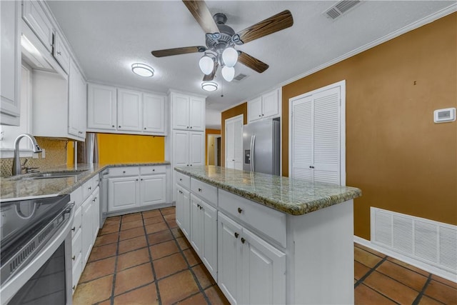 kitchen featuring a center island, sink, tasteful backsplash, white cabinetry, and stainless steel appliances