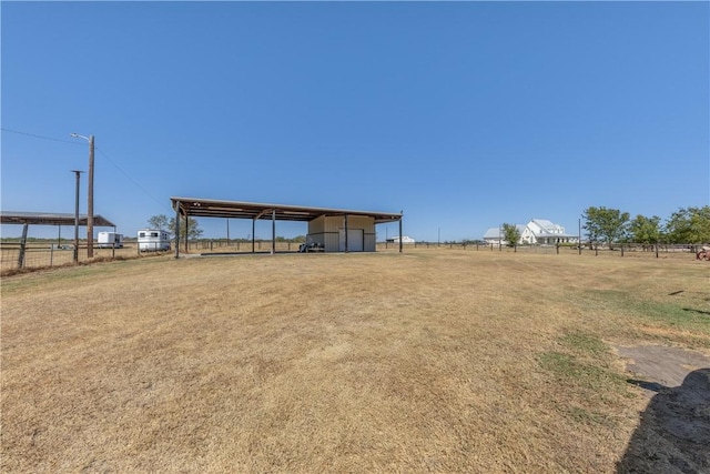 view of yard with a rural view and an outdoor structure