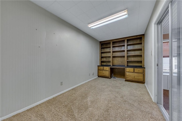 unfurnished office with built in desk and light colored carpet