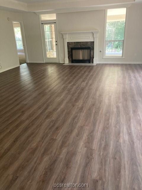 unfurnished living room featuring a fireplace, dark hardwood / wood-style flooring, and crown molding