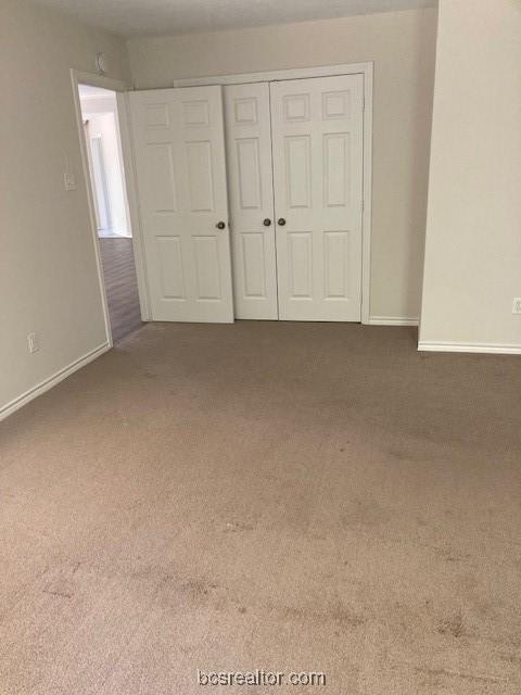 unfurnished bedroom featuring carpet floors and a closet