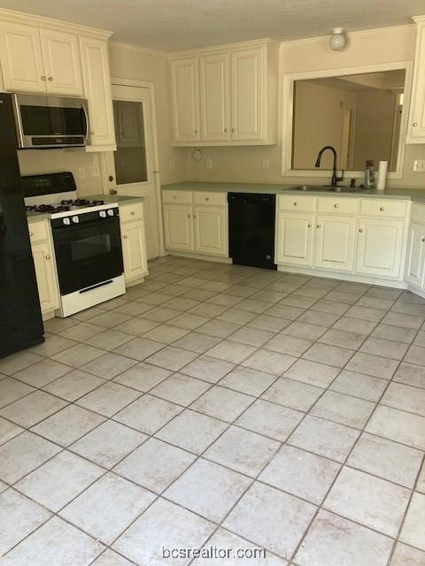 kitchen with refrigerator, sink, white gas range, black dishwasher, and light tile patterned flooring