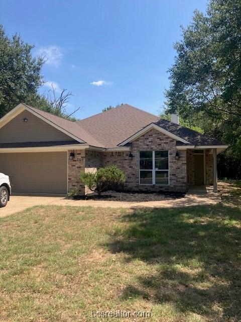 ranch-style home with a garage and a front lawn