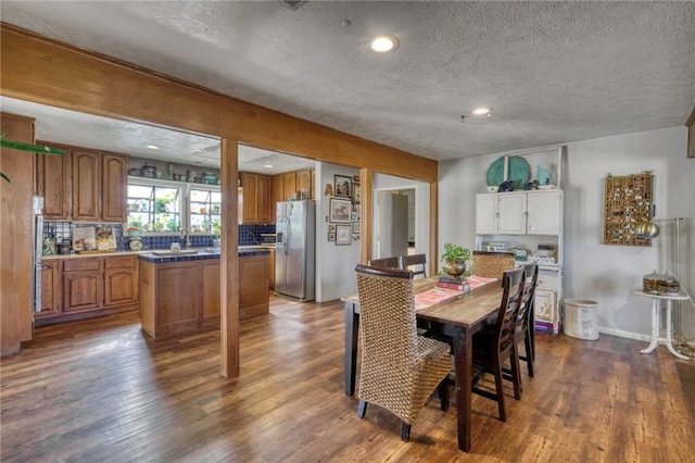 dining space with dark hardwood / wood-style flooring and a textured ceiling