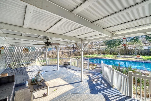 deck with ceiling fan and a fenced in pool