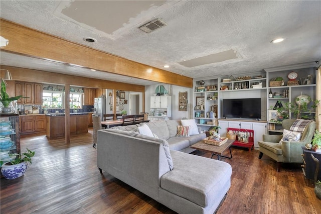 living room with dark hardwood / wood-style flooring and a textured ceiling