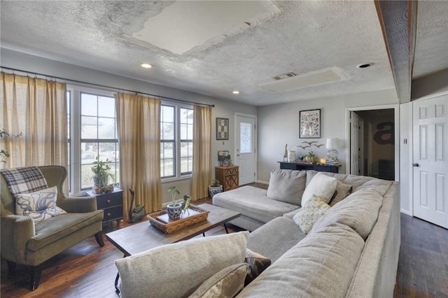 living room featuring dark wood-type flooring and a textured ceiling