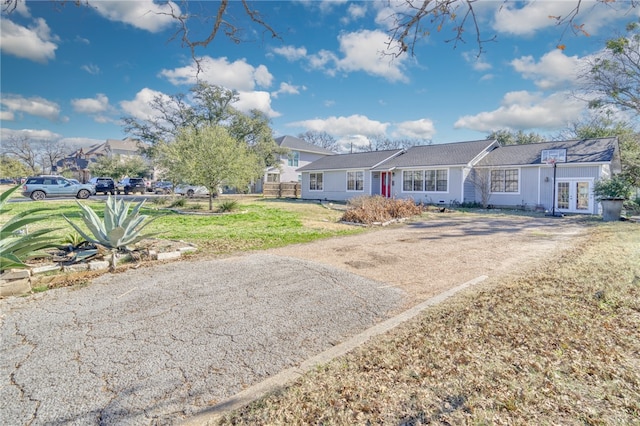 ranch-style house featuring french doors and a front lawn