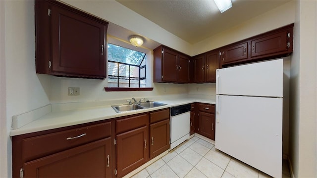 kitchen with sink, light tile patterned floors, and white appliances