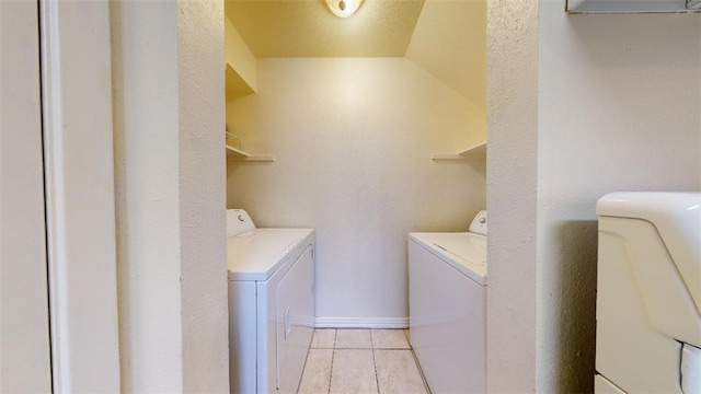 laundry room featuring washing machine and dryer and light tile patterned flooring