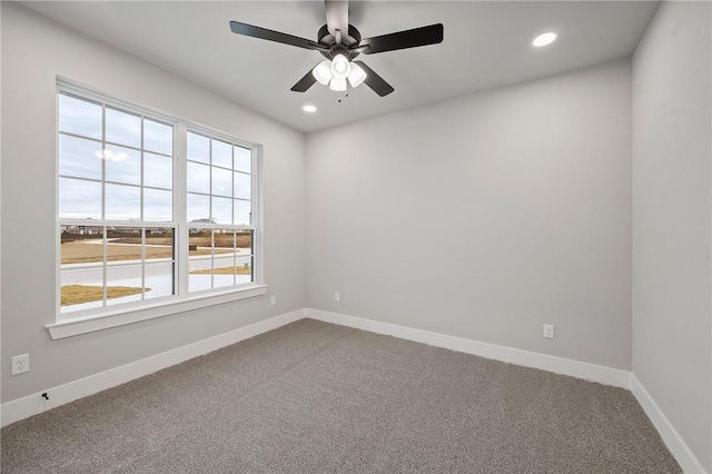 carpeted spare room featuring ceiling fan