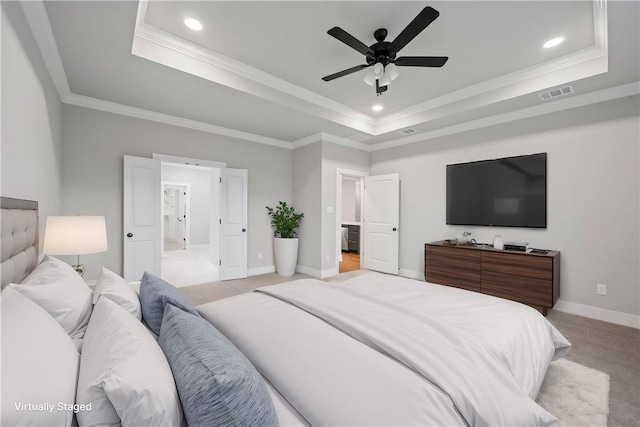 carpeted bedroom featuring ceiling fan, crown molding, and a tray ceiling