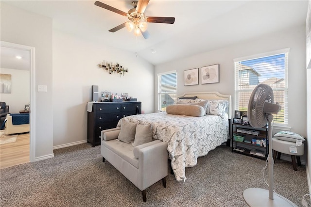 carpeted bedroom with ceiling fan and vaulted ceiling