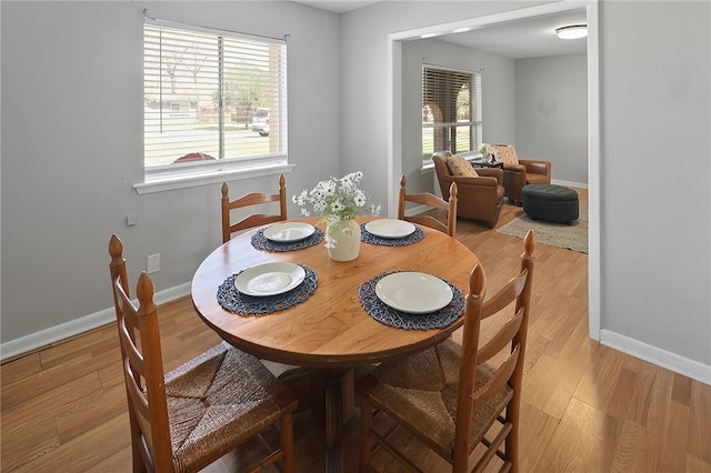 dining area with baseboards and wood finished floors