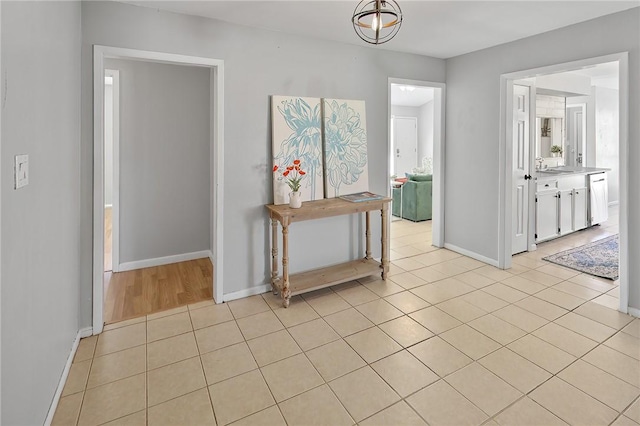 hallway with baseboards and light tile patterned flooring