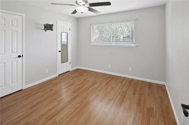 unfurnished room featuring light wood-type flooring, baseboards, and a ceiling fan