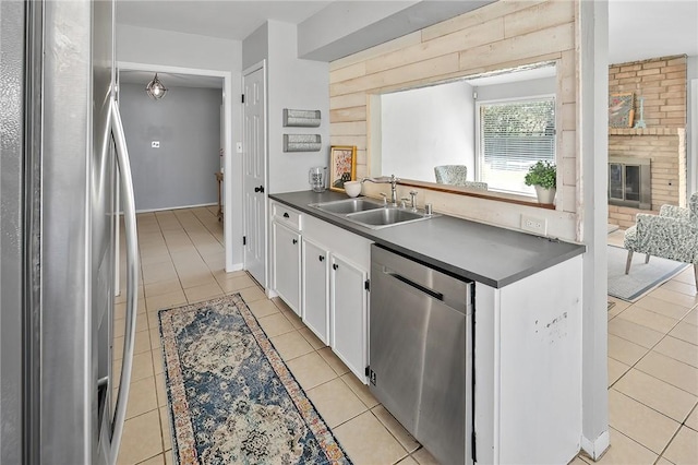 kitchen featuring a sink, dark countertops, white cabinetry, appliances with stainless steel finishes, and light tile patterned flooring