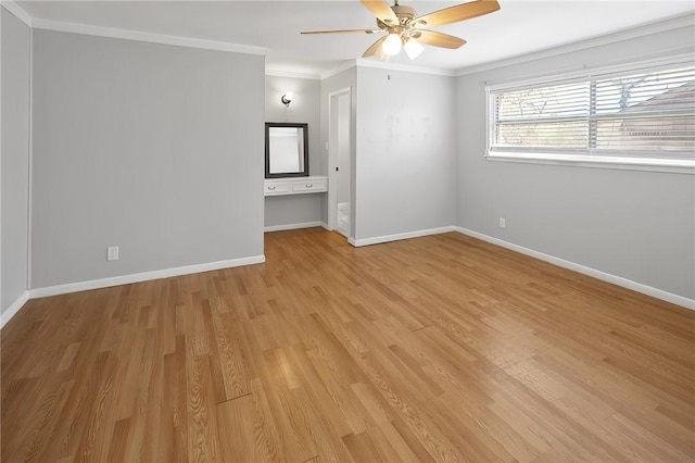 spare room featuring light wood-type flooring, baseboards, ceiling fan, and crown molding