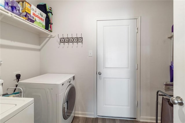 laundry area featuring washing machine and clothes dryer and dark hardwood / wood-style flooring