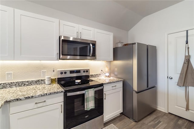 kitchen with lofted ceiling, stainless steel appliances, dark hardwood / wood-style floors, light stone counters, and white cabinets